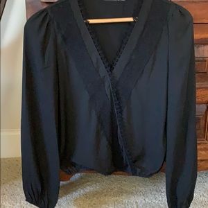 Long sleeve black polyester top snaps in center